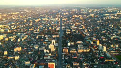 Video - Aerial drone hyperlapse view of Chisinau downtown at sunset. Multiple buildings, trees, parks, road with mooving cars. Moldova