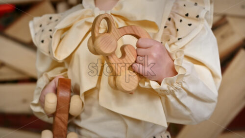 Video - Little girl holding two wooden snail rolling toys. Ecological and sustainability concept