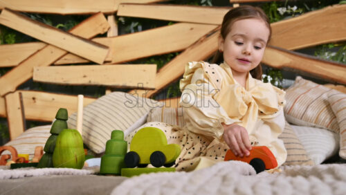 Video - Little girl playing with a wooden rolling bus toy among others ecological toys. Sustainability concept