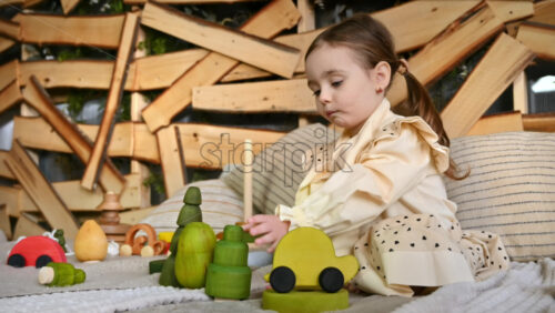 Video - Little girl playing with a wooden fir tree toy among others ecological toys. Sustainability concept
