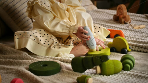 Video - Little girl playing with a wooden poplar tree toy among others ecological toys. Sustainability concept