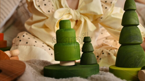 Video - Little girl playing with several green wooden tree toys. Ecological and sustainability concept