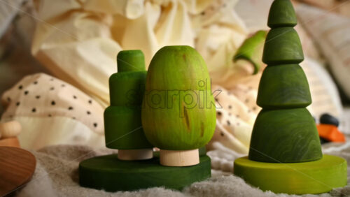 Video - Little girl playing with several green wooden tree toys. Ecological and sustainability concept
