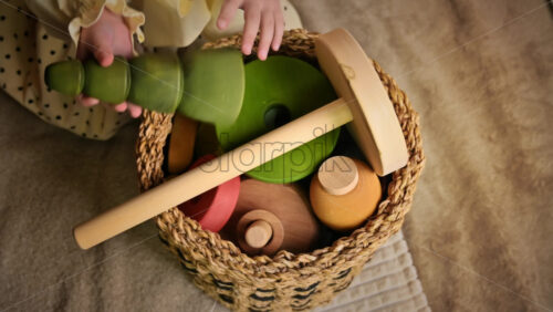 Video - Overhead view of the little girl's hands put wooden toys in the basket. Ecological and sustainability concept