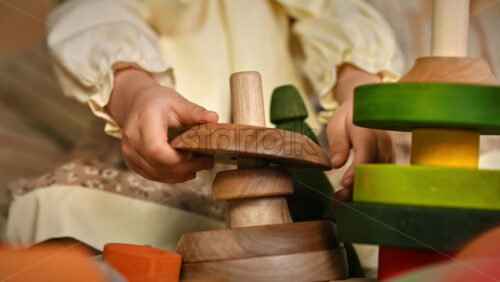 Video - Little girl's hands playing with a wooden stacking jug. Ecological and sustainability concept