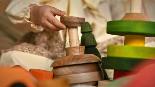 Video - Little girl's hands playing with a wooden stacking jug. Ecological and sustainability concept