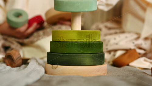 Video - Two little girls playing with vibrantly colored blocks of a large wooden pyramid. Ecological and sustainability concept