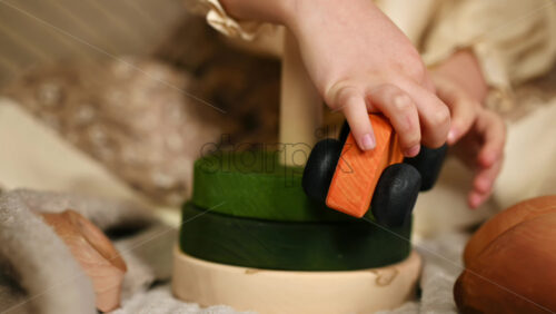 Video - Little girl's hand playing with a a wooden rolling bus toy on the wooden pyramid. Ecological and sustainability concept