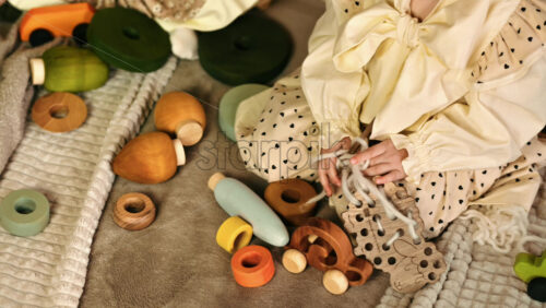 Video - Overhead view of two little girls playing with wooden toys on the bed. Ecological and sustainability concept