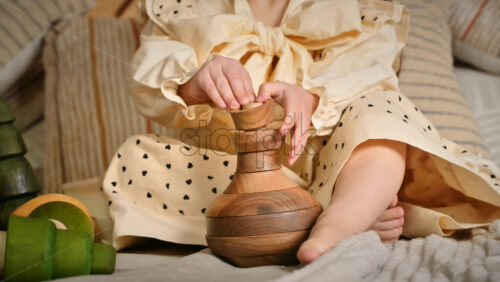 Video - Little girl's hands playing with a wooden stacking jug. Ecological and sustainability concept