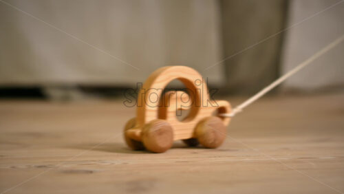 Video - Little girl playing with a wooden snail rolling toy on the floor. Ecological and sustainability concept