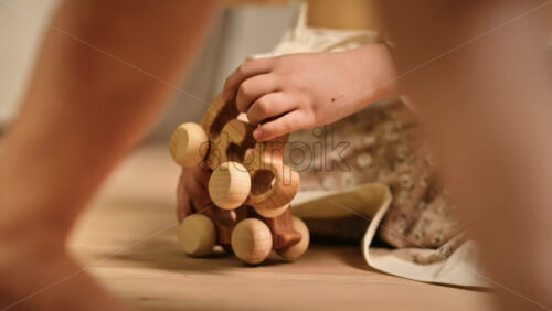 Video - Two little girls playing with wooden snail rolling toys on the floor. Ecological and sustainability concept