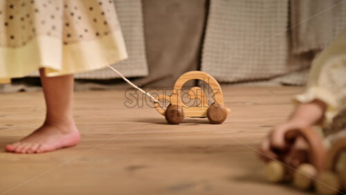 Video - Little girl playing with a wooden snail rolling toy on the floor. Ecological and sustainability concept