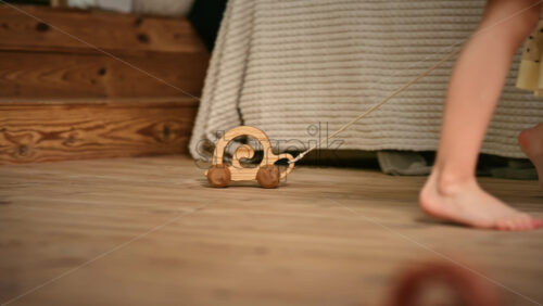 Video - Little girl playing with a wooden snail rolling toy on the floor. Ecological and sustainability concept