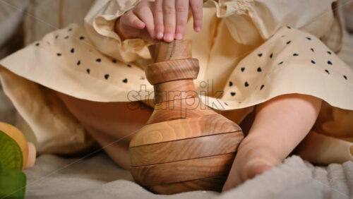 Video - Little girl's hands playing with a wooden stacking jug. Ecological and sustainability concept