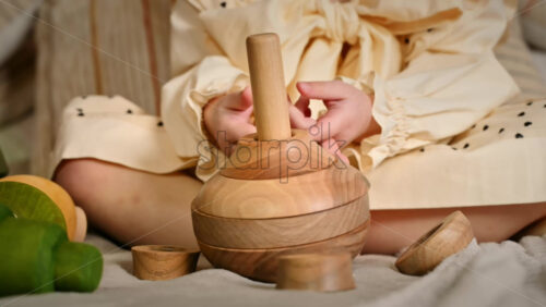 Video - Little girl's hands playing with a wooden stacking jug. Ecological and sustainability concept