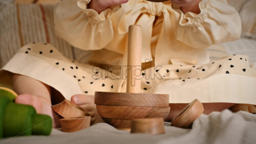 Video - Little girl's hands playing with a wooden stacking jug. Ecological and sustainability concept