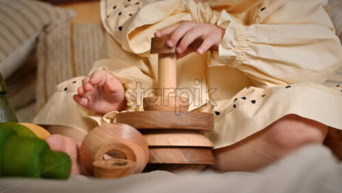 Video - Little girl's hands playing with a wooden stacking jug. Ecological and sustainability concept