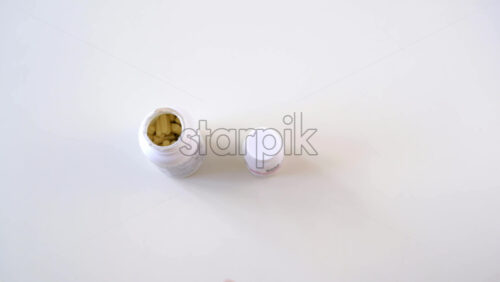 Video - Female hand taking vitamins from two bottles and then closing it. Healthy lifestyle idea. Quarantine