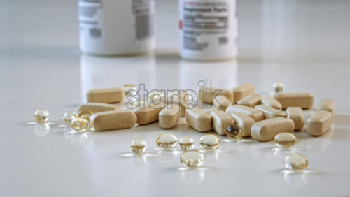 Video - A lot of vitamin pills lying on the table near two bottles. Health improvement idea