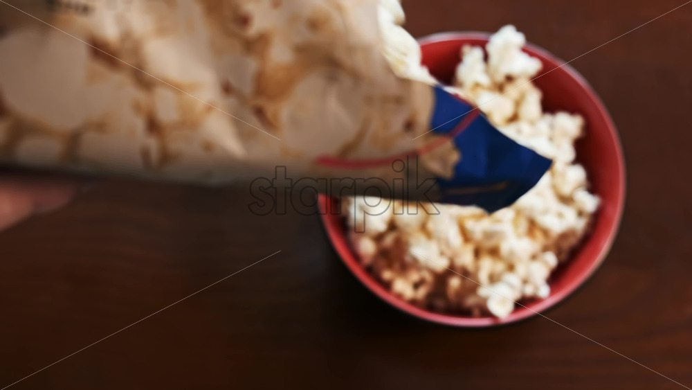 Video - Pouring the popcorn out of the bag and into a dish. Top view