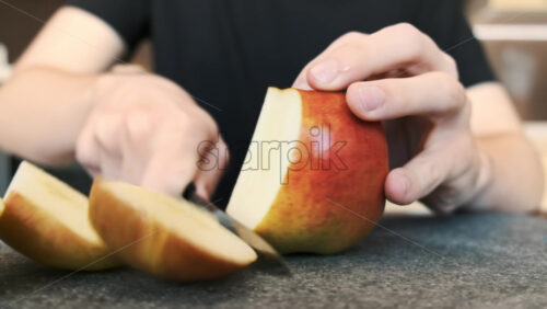 Video - A man slicing an apple on a cooking board using a knife