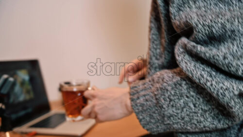 Video - Young girl making tea and coming to table. Content creator working from home. Laptop, microphone, headphones