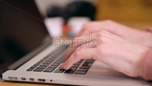 Video - Female hands typing on laptop with headphones on background. Working from home