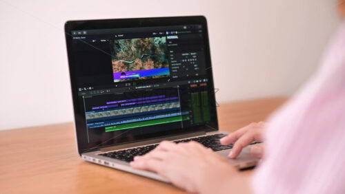 Video - Young content creator girl editing video on her laptop. Working from home