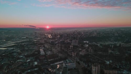 Video - Hyperlapse of Chisinau at sunrise, drone view. Multiple buildings, roads with moving cars, smoke getting off the tubes. Moldova