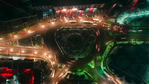 Video - Hyperlapse of a roundabout intersection at night, drone view. Roads with moving cars, night city illumination. Chisinau, Moldova