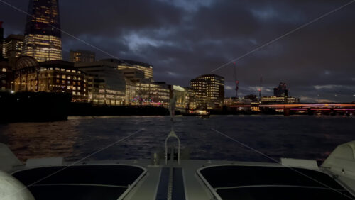 Video - The flag of the United Kingdom waving on a boat moving on the Thames River in the evening in London, England