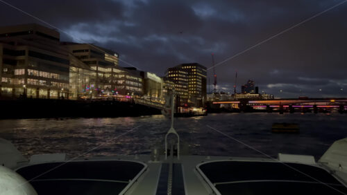 Video - The flag of the United Kingdom waving on a boat moving on the Thames River in the evening in London, England