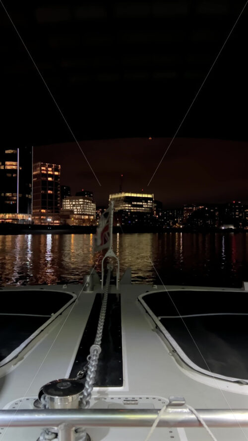 Video - The flag of the United Kingdom waving on a boat moving on the Thames River in the evening in London, England. Vertical