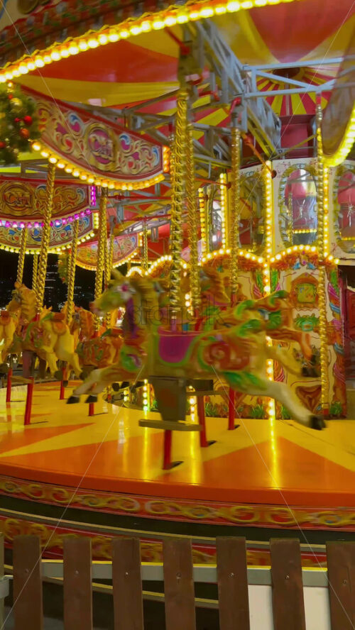 Video - Carousel spinning in the courtyard of the Battersea Power Station Mall in the evening in London, England. Vertical