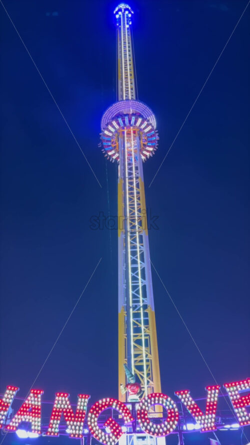 Video - The Hangover ride moving up at Winter Wonderland in the Hyde Park in London, England, in the evening. Vertical