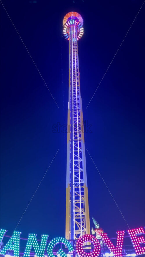 Video - The Hangover ride coming down at Winter Wonderland in the Hyde Park in London, England, in the evening. Vertical