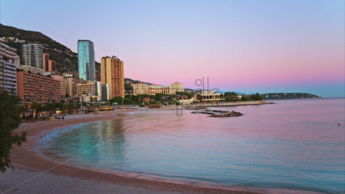 Video - View of the Larvotto Beach in Monaco at sunset with the skyline of the city on the background