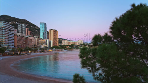Video - View of the Larvotto Beach in Monaco at sunset with the skyline of the city on the background