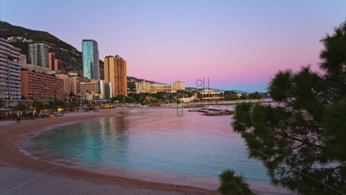 Video - View of the Larvotto Beach in Monaco at sunset with the skyline of the city on the background