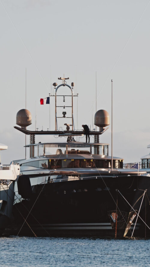 Video - View of a man working on a boat docked in the Port de Cannes in France. Vertical