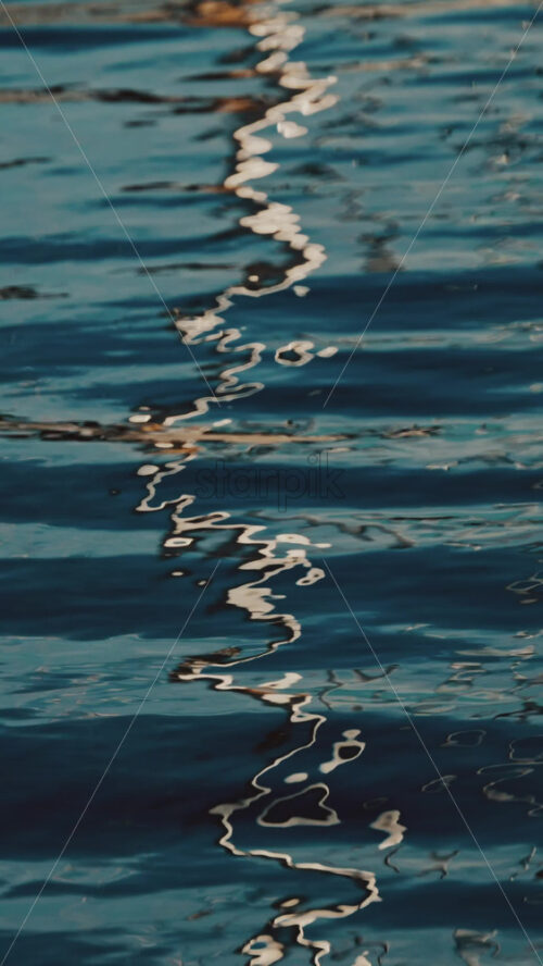 Video - Reflections of the city on the waves of the sea. Vertical