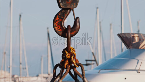 Video - A crane machine moving down near boats docked in a harbour