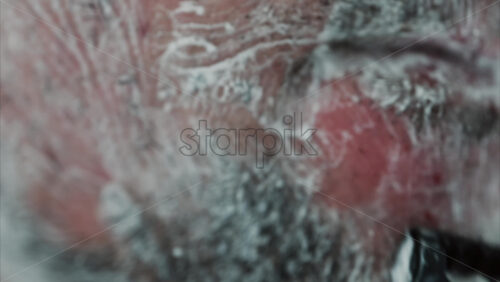 Video - Close up of a man shaving his beard with a razor