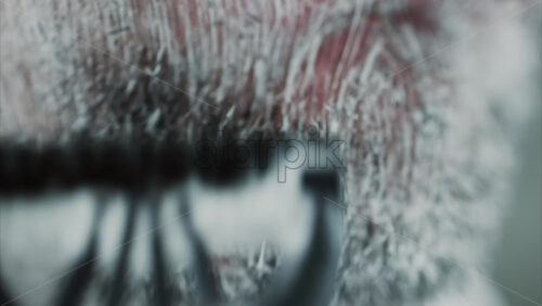 Video - Close up of a man shaving his beard with a razor