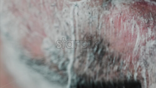 Video - Close up of a man shaving his beard with a razor