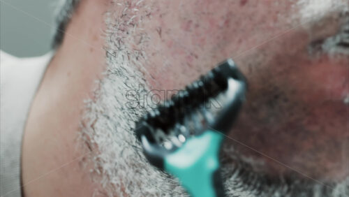 Video - Close up of a man shaving his beard with a razor