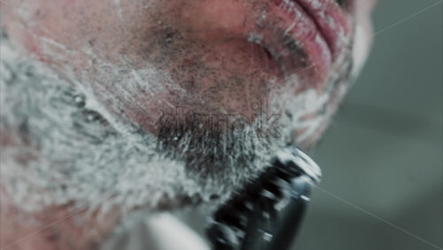 Video - Close up of a man shaving his beard with a razor