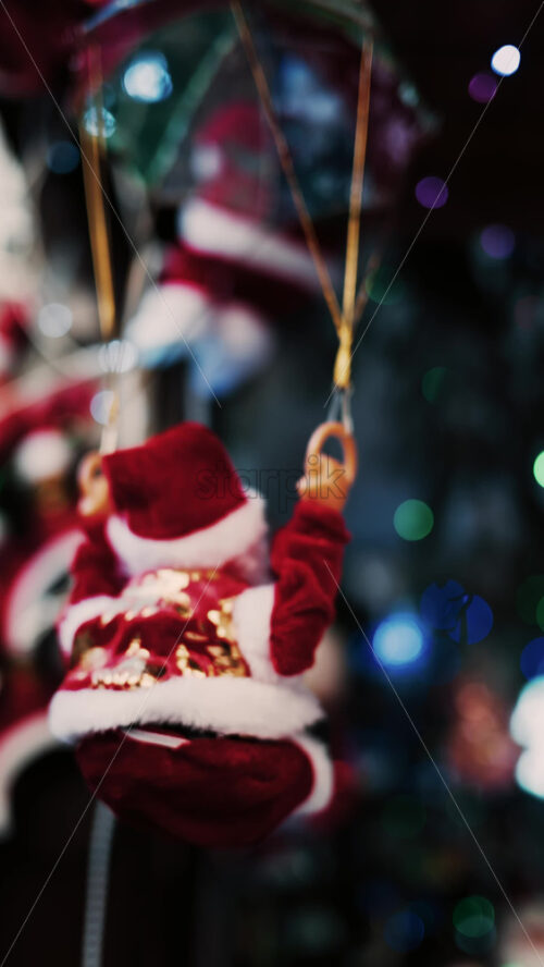 Video - Santa Claus toy rotating back and forth with a blurry background. Vertical