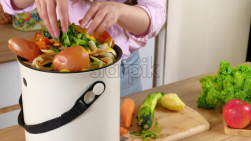 Video - Woman recycling organic waste by composting vegetables peels in the Bokashi in the kitchen